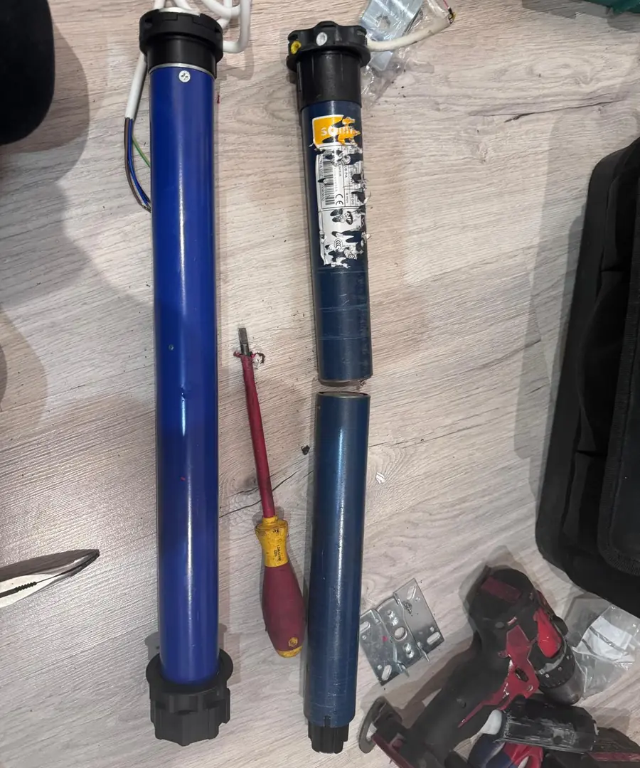 Dos motores tubulares azules apoyados en el suelo junto a las herramientas de trabajo